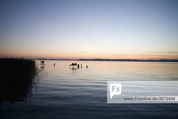 Silhouette of people bathing in a lake Hungary