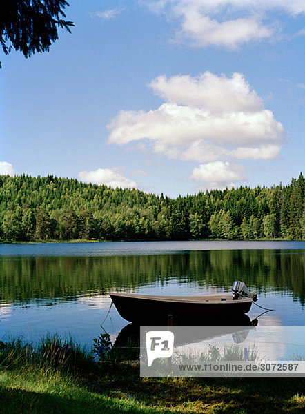 Ein Boot in einem See so glatt wie ein Spiegel Schweden