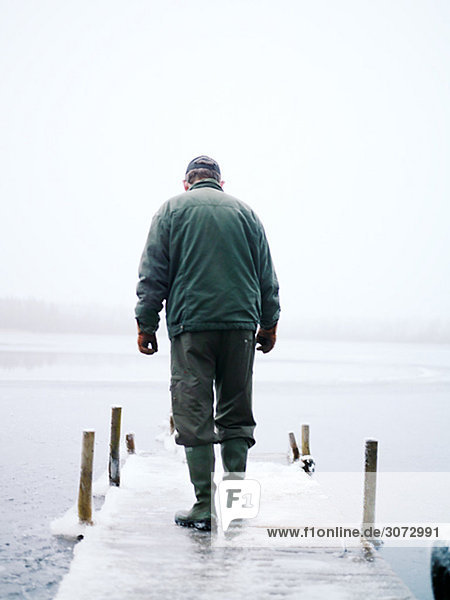 Ein alter Mann zu Fuß auf einer Mole Schweden