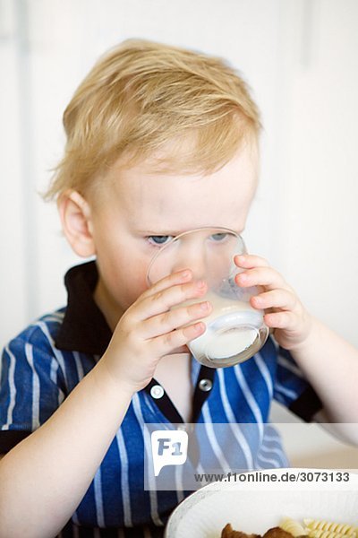 A boy drinking a glass of milk Sweden.
