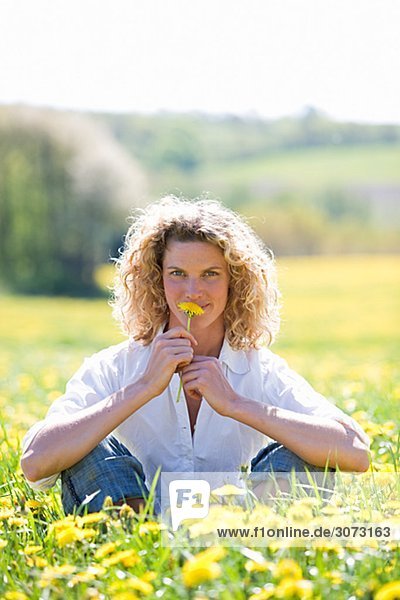 A woman sitting in a field of dandelions Sweden.