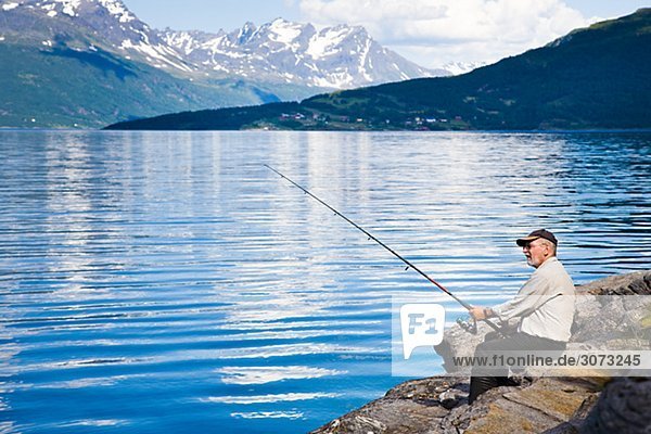 Man fishing in the fiord Gratangen Norway.