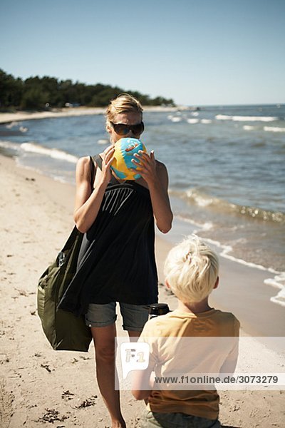 Mother inflating beach ball Gotland Sweden.