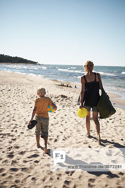 Mother and son walking on the beach Gotland Sweden.