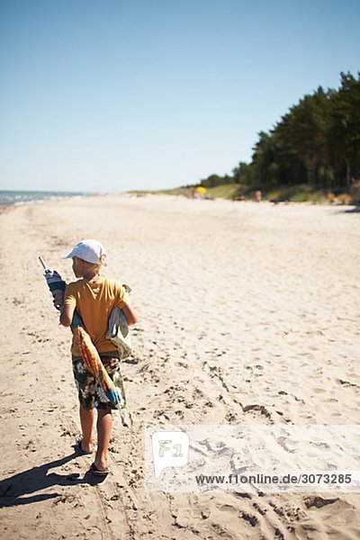 A boy walking on the beach Gotland Sweden.