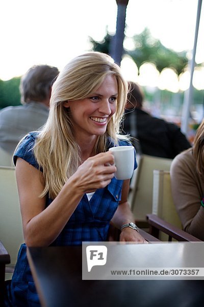 A young woman drinking a cup of coffee Stockholm Sweden.