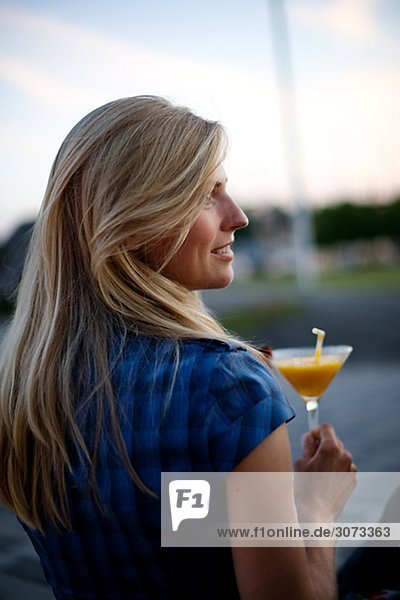 A young woman holding a drink Stockholm Sweden.