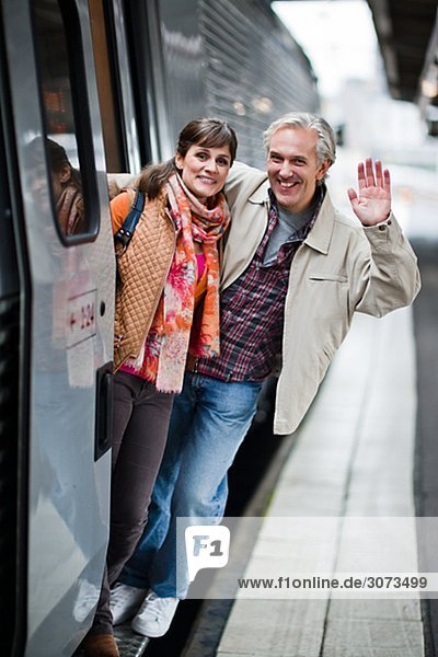 A couple by a train at a railway station Sweden.