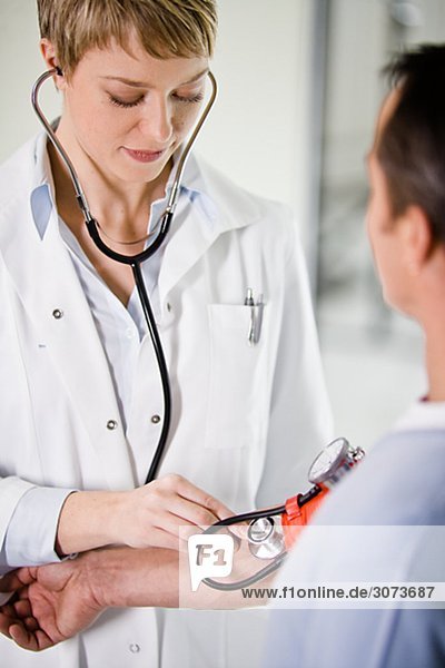 A female doctor using a blood-pressure gauge Sweden.