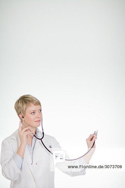A female doctor listening into a stethoscope Sweden.