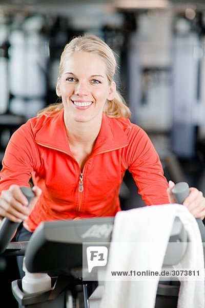 A woman doing indoor cycling at a gym Sweden.