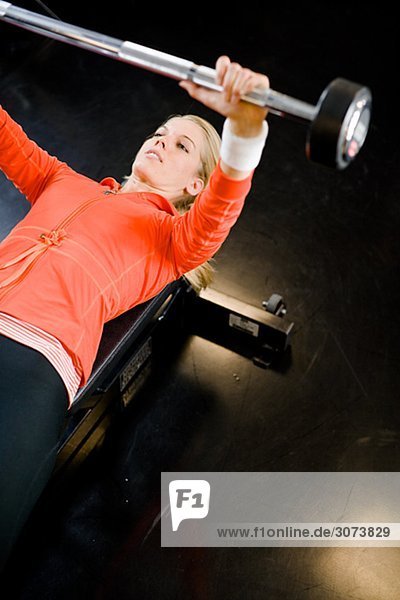 A woman weight training at a gym Sweden.