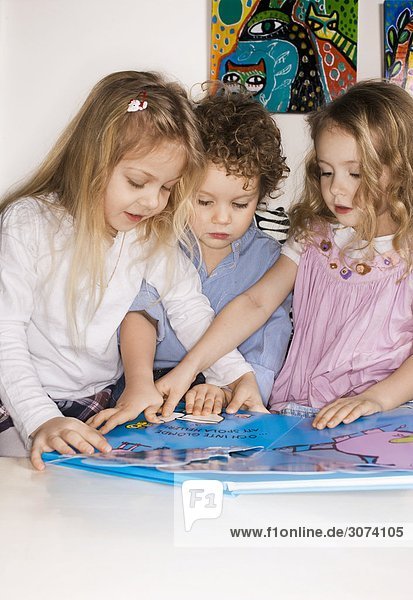 Drei Kinder mit ein Bilderbuch Schweden.