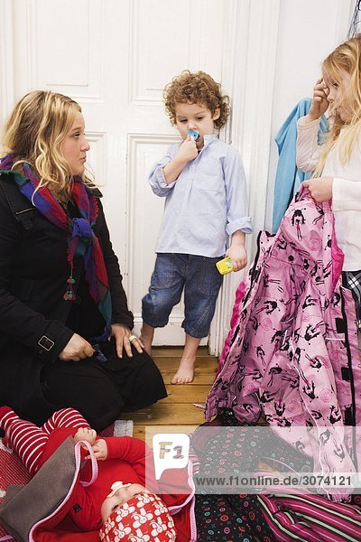Mutter ihre Kinder in einem Korridor Schweden dressing.