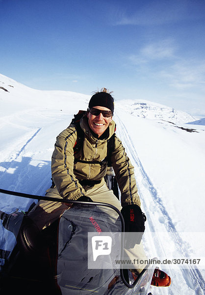 Young man riding snowmobile