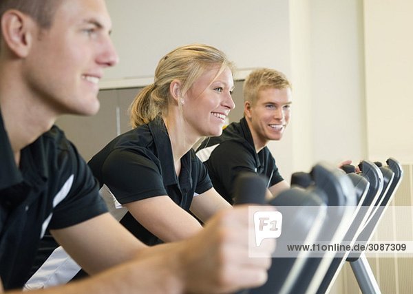 Drei lächelnde Menschen beim Training