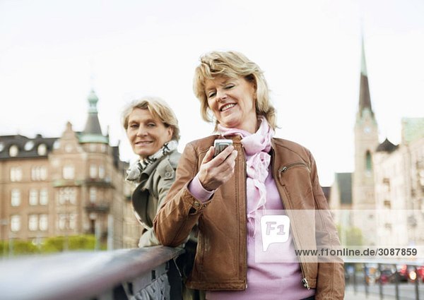 Frauen auf Brücke mit Handy
