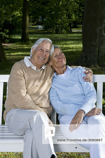 Ein älteres Paar  das zusammen auf einer Bank sitzt.