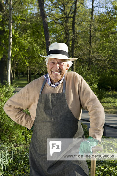 A senior man dressed for gardening taking a break