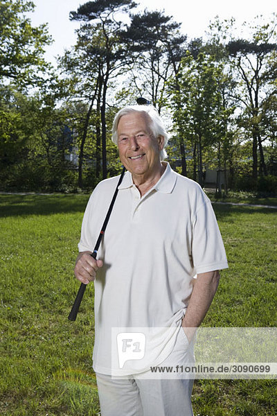 A senior man holding a golf club