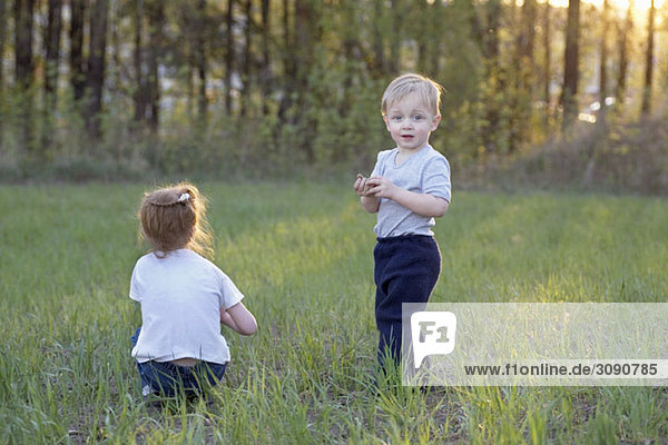 Ein junger Bruder und eine junge Schwester auf einem Feld.