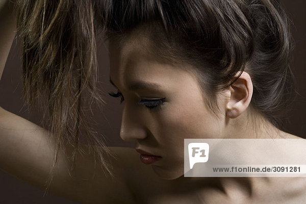 Side view of a teenage girl holding her hair up