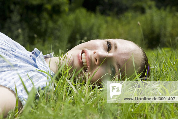 Eine junge Frau im Gras liegend