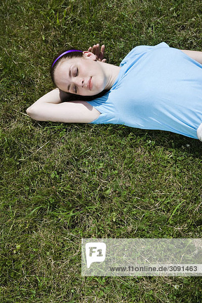 Eine junge Frau  die im Gras liegt und schläft.