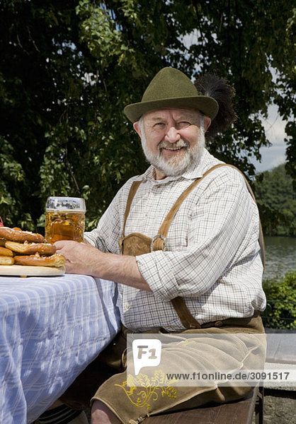 Ein traditionell gekleideter deutscher Mann in einem Biergarten