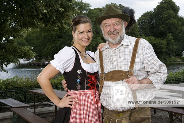Ein traditionell gekleideter deutscher Mann und Frau im Biergarten  Porträt
