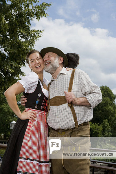 Ein traditionell gekleideter deutscher Mann und Frau in einem Biergarten