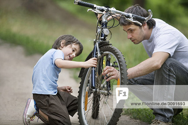 A father and son repairing a bicycle
