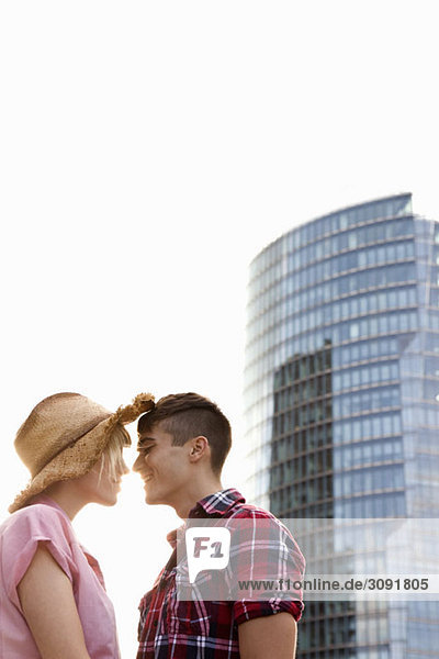 A young couple  face to face  in front of a skyscraper  Berlin  Germany
