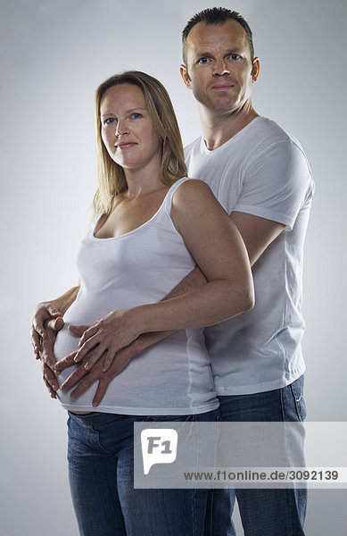 Mann umarmt schwangere Frau