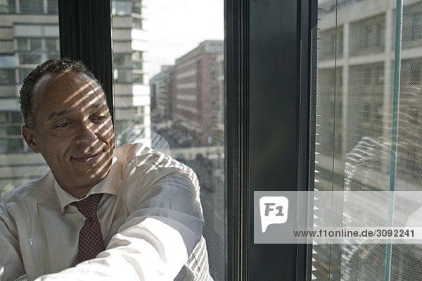 man leaning at window smiling