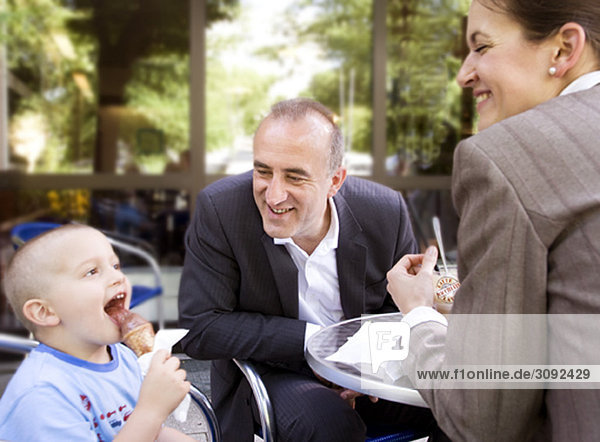 business couple with son in outdoor cafe