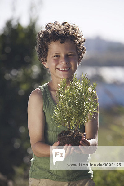 Kleiner Junge mit kleiner Pflanze