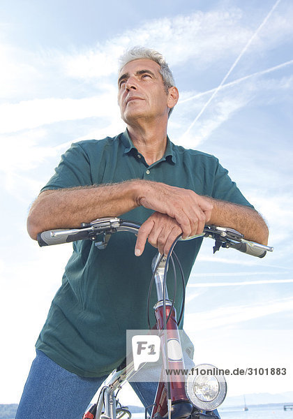 Senior auf Fahrrad  gegen Himmel