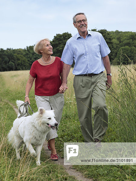 Seniorenpaar  gehen mit Hund Spazieren