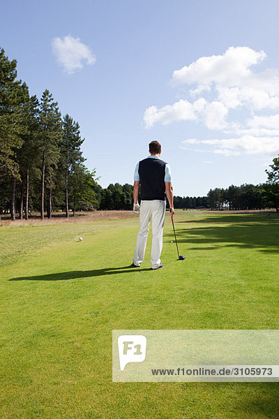 Rear view of a male golfer on the fairway