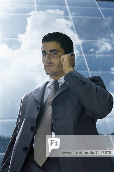 Businessman using cell phone outside office building