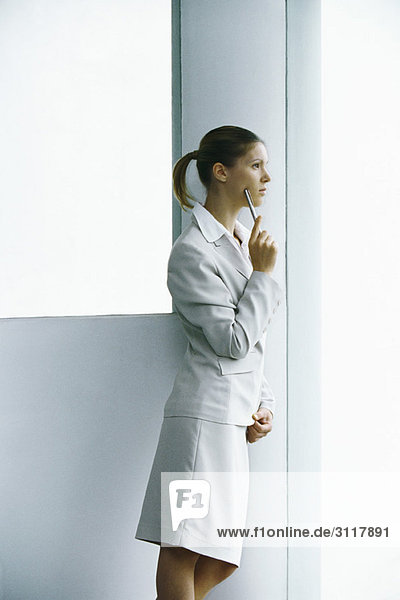 Businesswoman waiting at entrance looking away thoughtfully