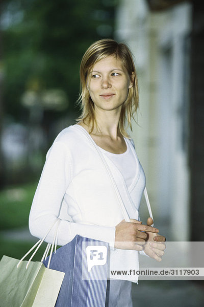 Woman carrying shopping bags on arm  portrait
