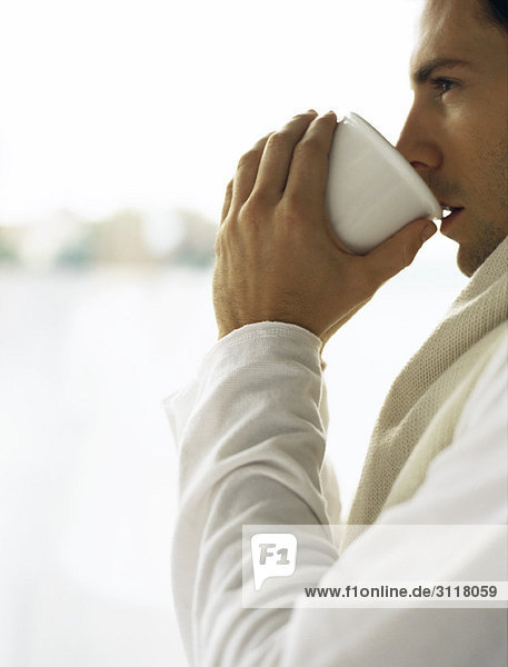 Man drinking cup of coffee  looking away