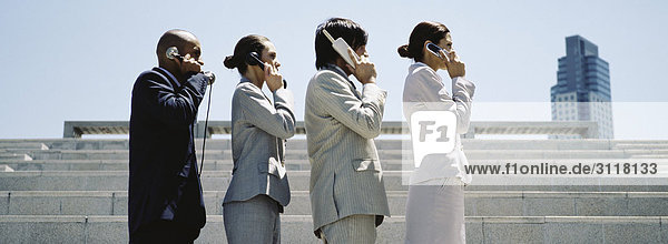 Professionell gekleidete Männer und Frauen in einer Linie mit sukzessiv weiterentwickelten Telefonen.