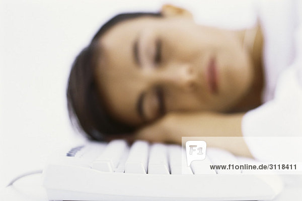 Woman asleep  resting head on computer keyboard