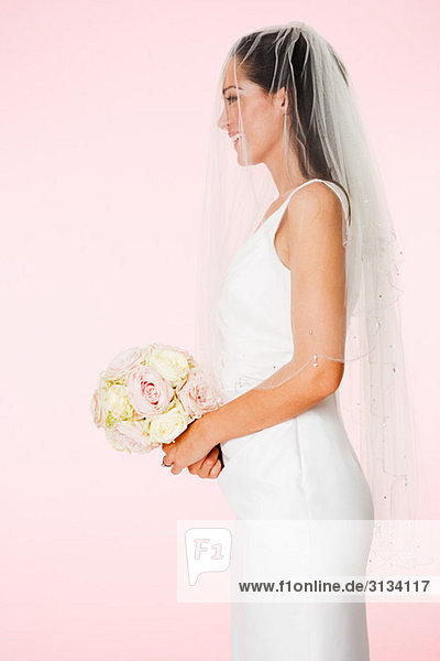 Side view of a bride holding a bouquet