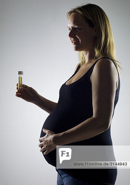 Schwangere mit Probeflasche