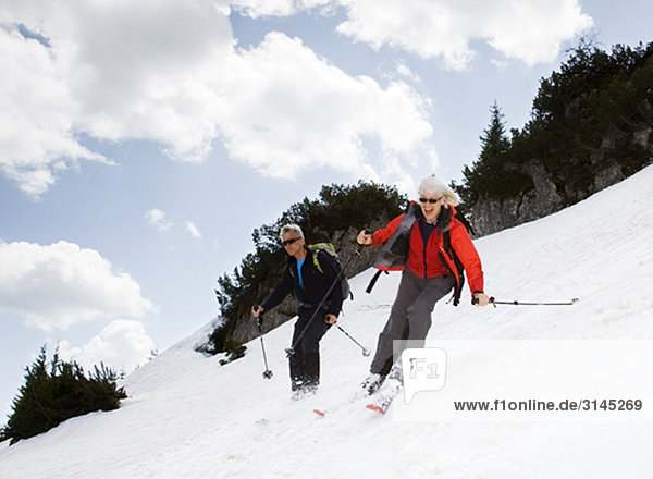 senior couple skiing in mountains