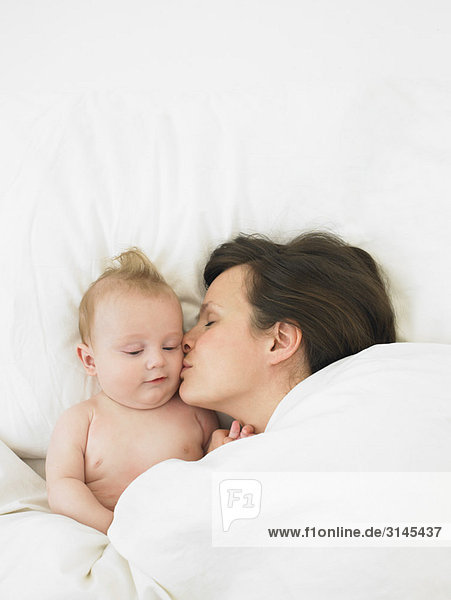 Baby und Mutter im Bett